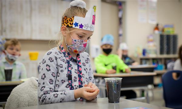 Girl plants seed in cup